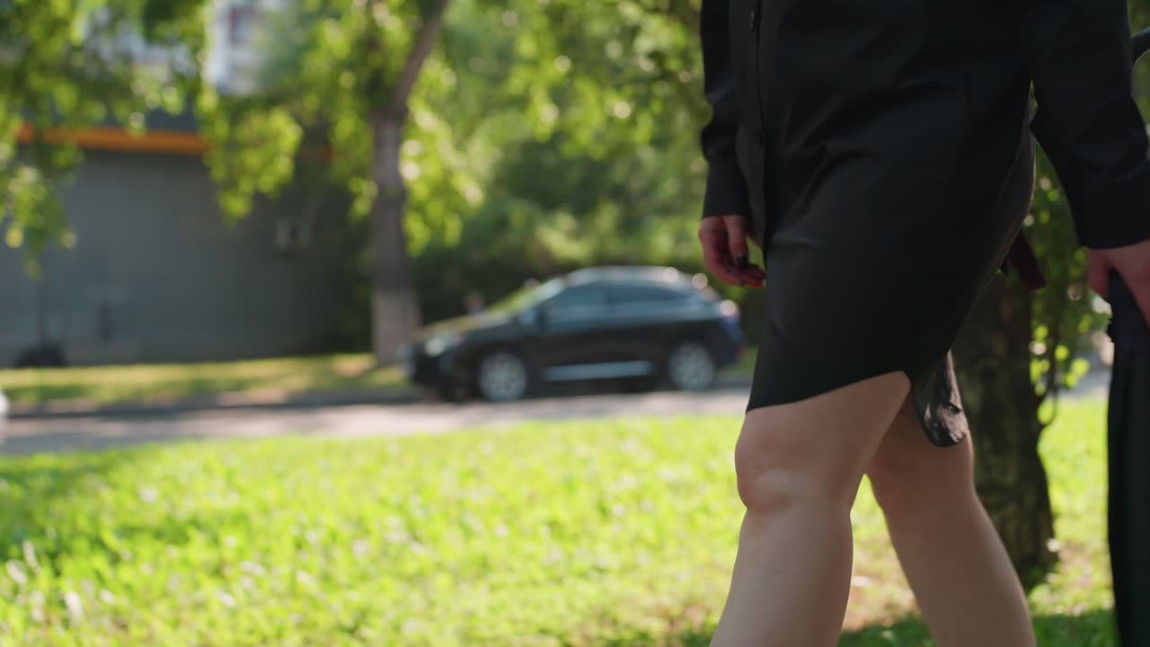 우아한 여성이 자신감 있게 밖을 걷고 있어요. 백인 전문직 여성이 햇볕이 잘 드는 보도를 거닐고, 우아한 외모의 전문직 여성이 햇볕이 좋은 공원 환경에서 여유롭게 산책하고 있습니다.