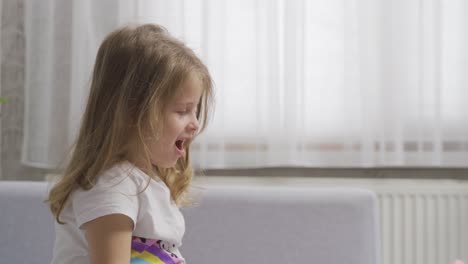 Little-girl-plays-alone-at-home-with-her-toys.