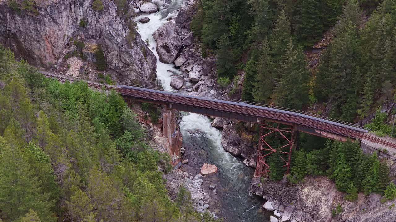 Majestic Railway Bridge Crosses a Roaring River Through a Verdant Mountain Valley in British Columbia