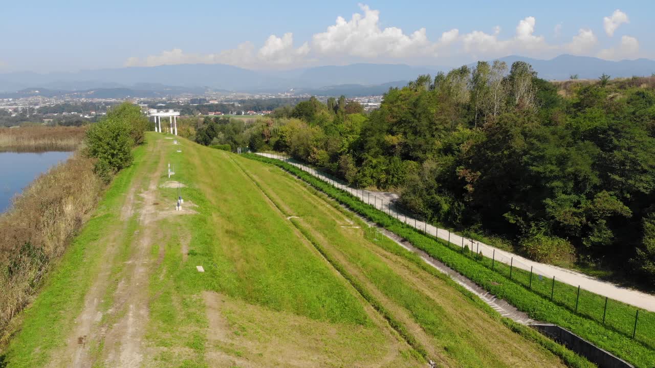 ladera cubierta de hierba al lado del lago de eliminación de productos químicos industriales con marcadores y respiraderos, vista aérea elevada