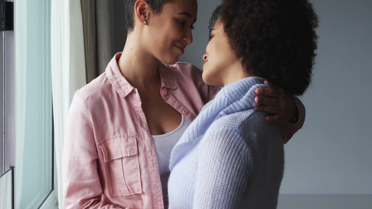 Lesbian couple romancing at window
