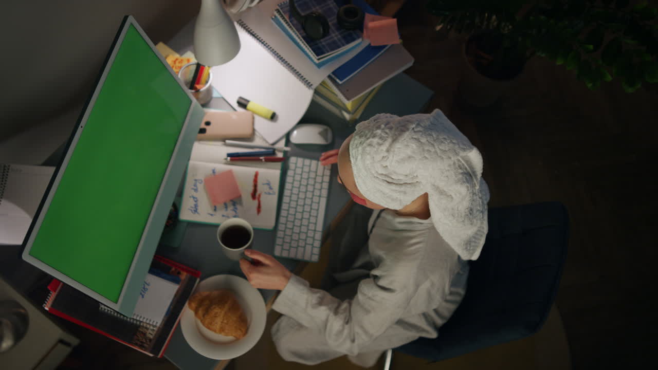 chica anónima bebiendo bebidas en casa de cerca. vista superior ama de casa escribiendo notas