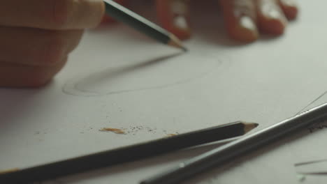 a person draws a circle on a piece of paper with a pencil