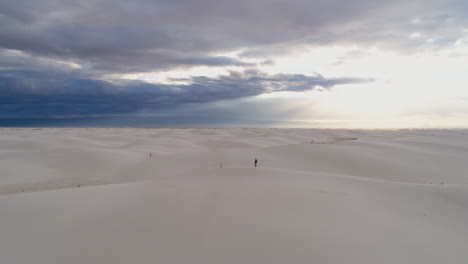 Umlaufende-Antenne-Einer-Kleinen-Person-In-Einem-Massiven-Weißen-Sanddünenfeld,-Sonnenaufgang,-4k