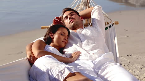 attractive couple sleeping together in a hammock