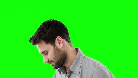 thoughtful man standing against green background