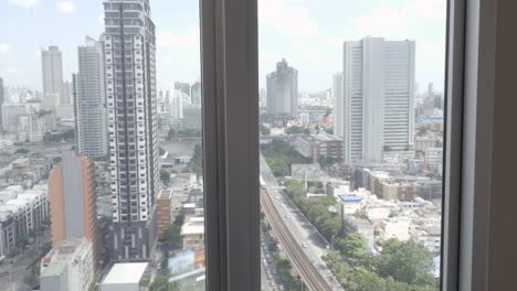 woman in bath relaxing from big city window view to bangkok thailand