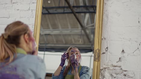 woman cleaning face from paints in front mirror using napkin