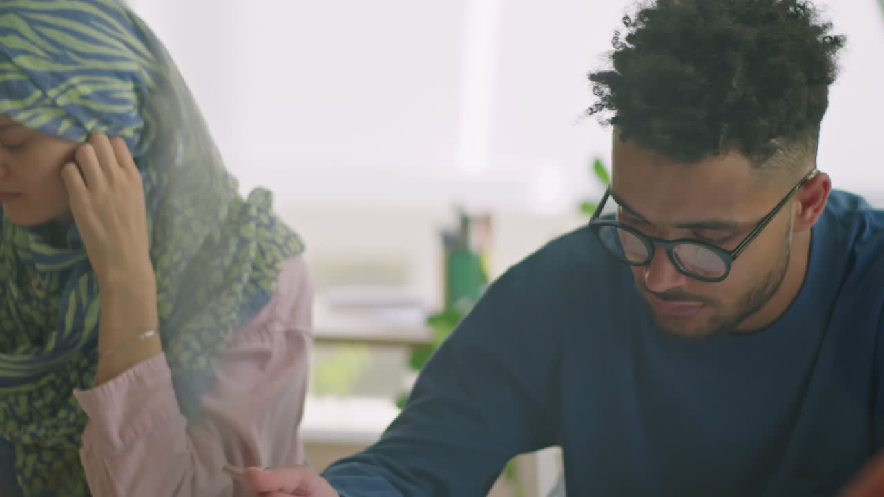 Teacher Helping Female Student in Hijab during Lesson