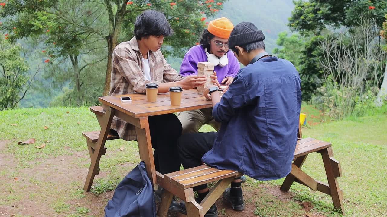 Amigos se divertindo em um encontro jogando torre de blocos de madeira em um café na natureza