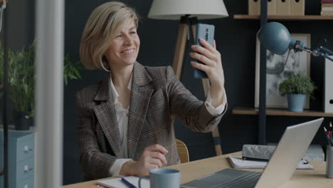 Woman taking a selfie in her office during a video call