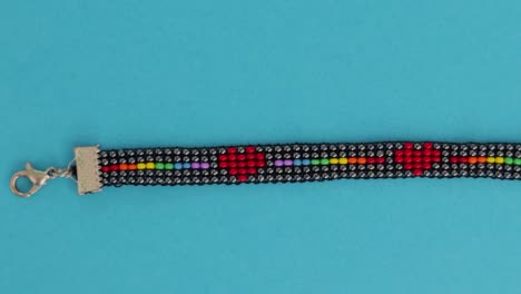 handmade lgbt bead pattern necklace over turquoise background