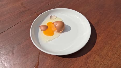 eggs break and spill onto a white plate