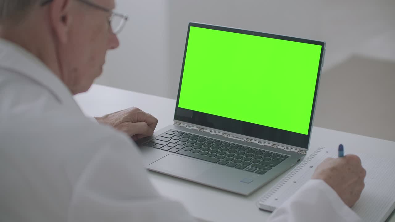 cuaderno con pantalla verde en la mesa del terapeuta que trabaja en la clínica, concepto de cita médica en línea