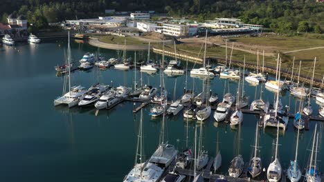 Tilt-up-shot-reveals-yachts-and-speedboats-docked-at-telaga-harbor-marina-and-fly-towards-perdana-quay-eco-marine-park-at-langkawi-island,-kedah,-archipelago-of-malaysia