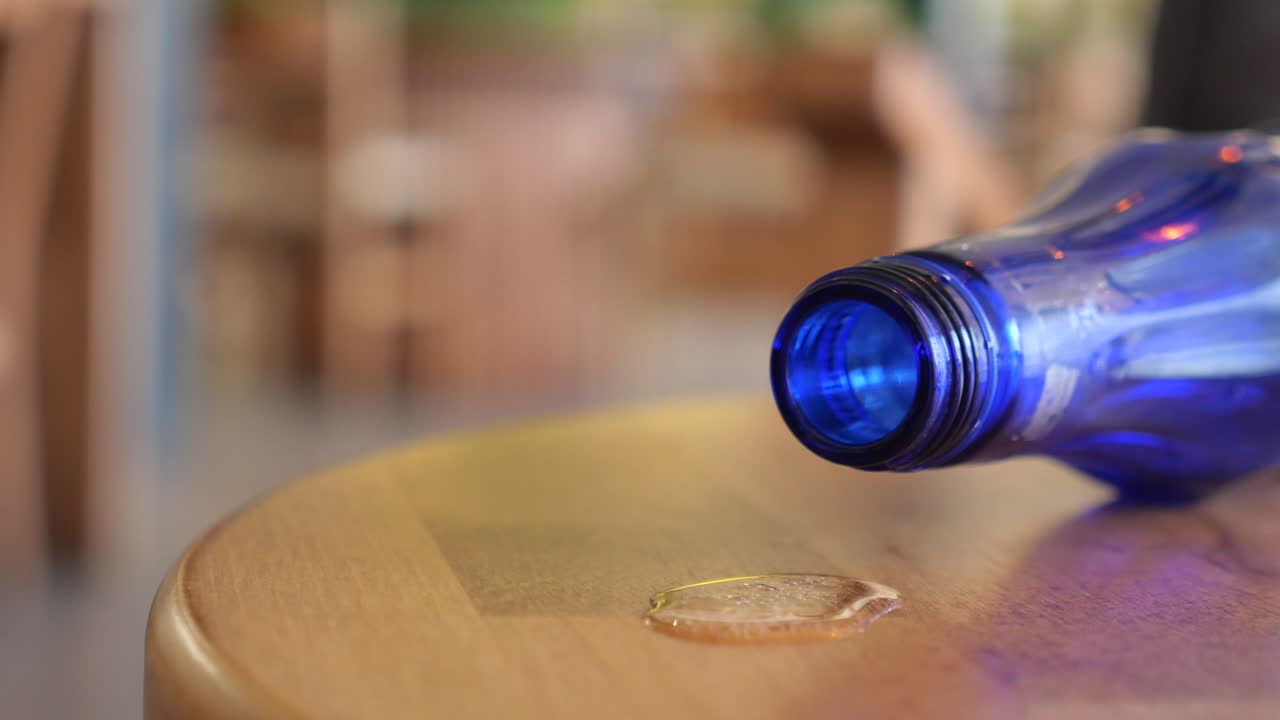 Blue Bottle Spilled on Wooden Table