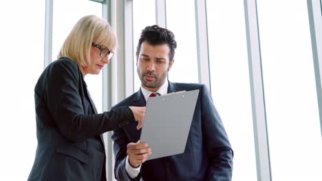 Two-business-people-talk-project-strategy-at-office