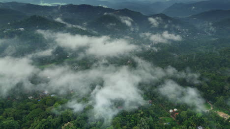 Vista-Aérea-Lejana-De-Una-Densa-Selva-Tropical,-Montañas-De-Vegetación-Y-Nubes-Brumosas,-Vistas-Reales-De-Munnar,-Kerala,-India.