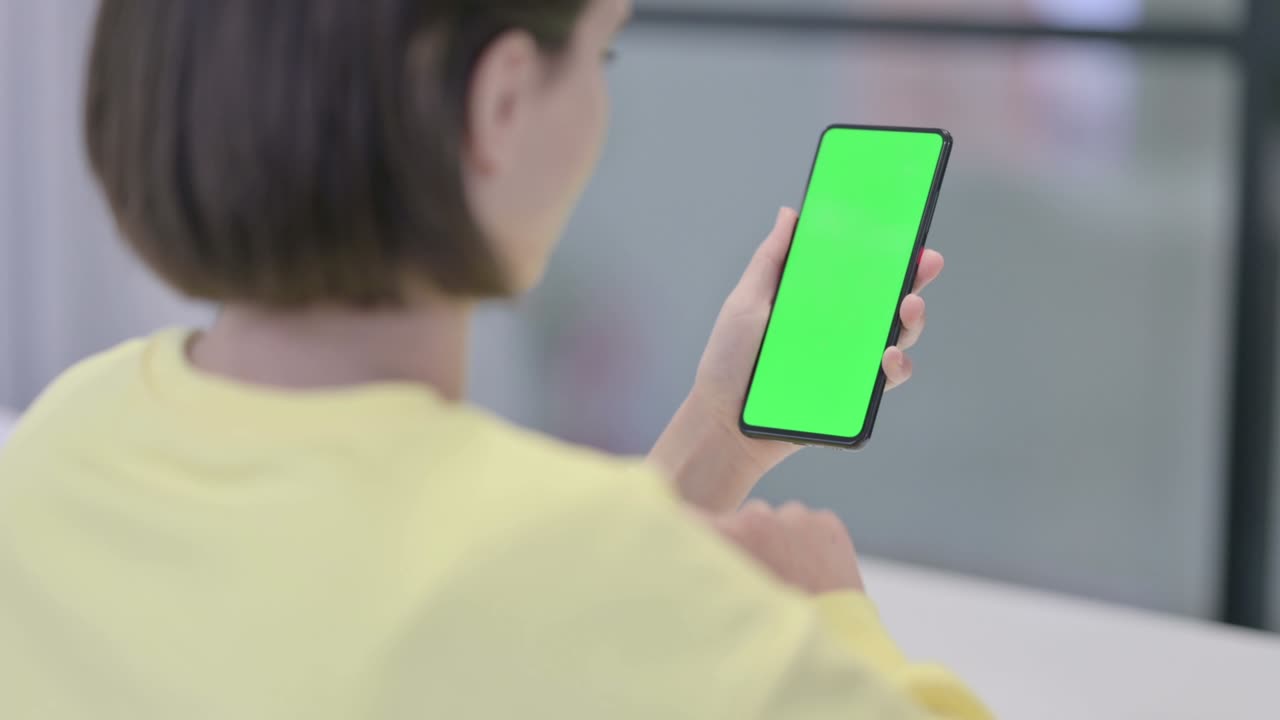 초록색 화면 을 가진 스마트폰 을 사용하는 여자