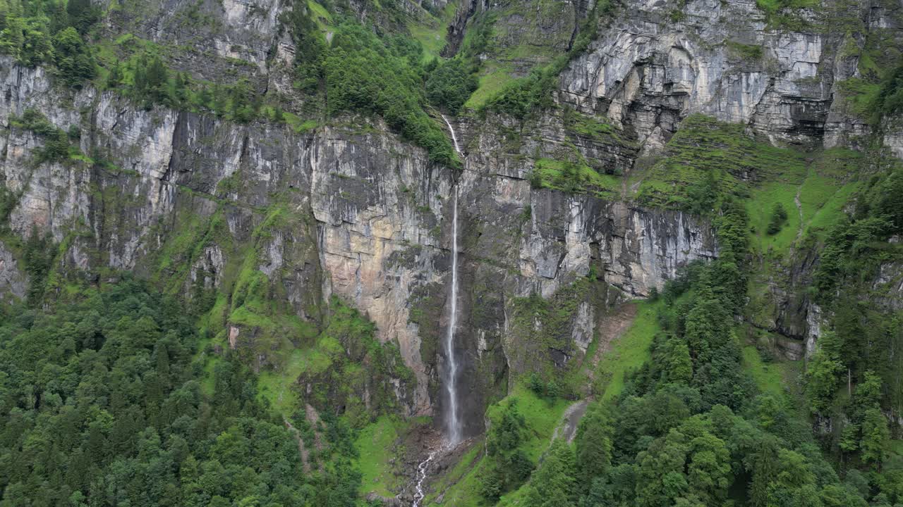 Bellissima cascata che scende dal terreno roccioso delle Alpi svizzere, ripresa aerea