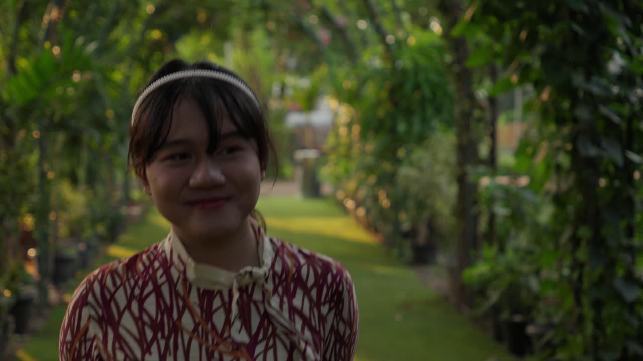 Portrait of a Smiling Young Woman in a Garden