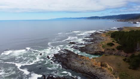 4k 30fps aerial footage oregon coast - rising drone shot of ocean waves crash against oceanside rock formations - pacific northwest nature