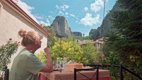 tourist dines at greek restaurant views kastraki rock formations meteora