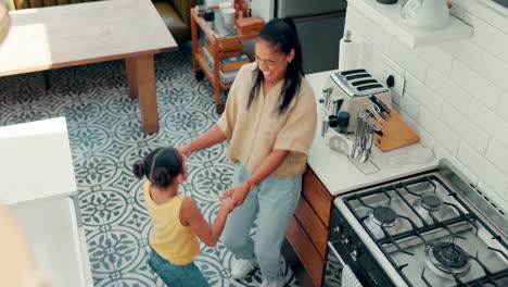 mother, child and happy dance in kitchen