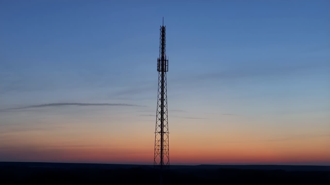 Telecommunication Tower Silhouette at Sunset with Red Light
