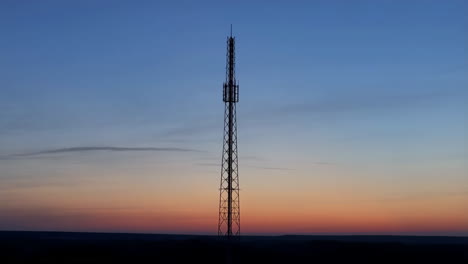 telecommunication tower silhouette at sunset with red light