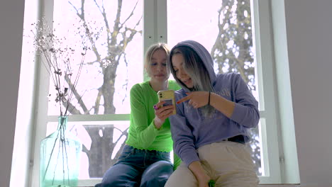 two girl friends talking while look at the phone