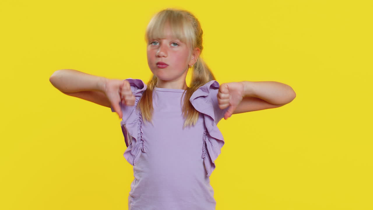 화를 내는 십대 전 소녀 엄지 손가락을 내리고, 나쁜 일을 싫어하고, 승인하지 않고, 불만족스러운 피드백