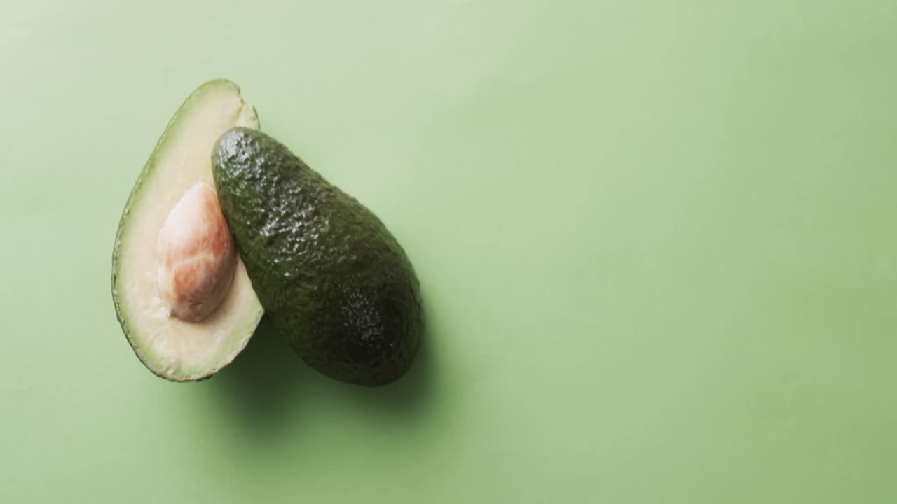 Video di avocado affettato con spazio per il testo su sfondo verde