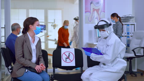 dentist assistant with ppe equipment talking with patient