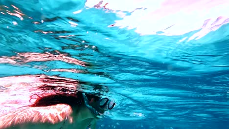 mujer nadando con peces en agua azul clara, zanzíbar