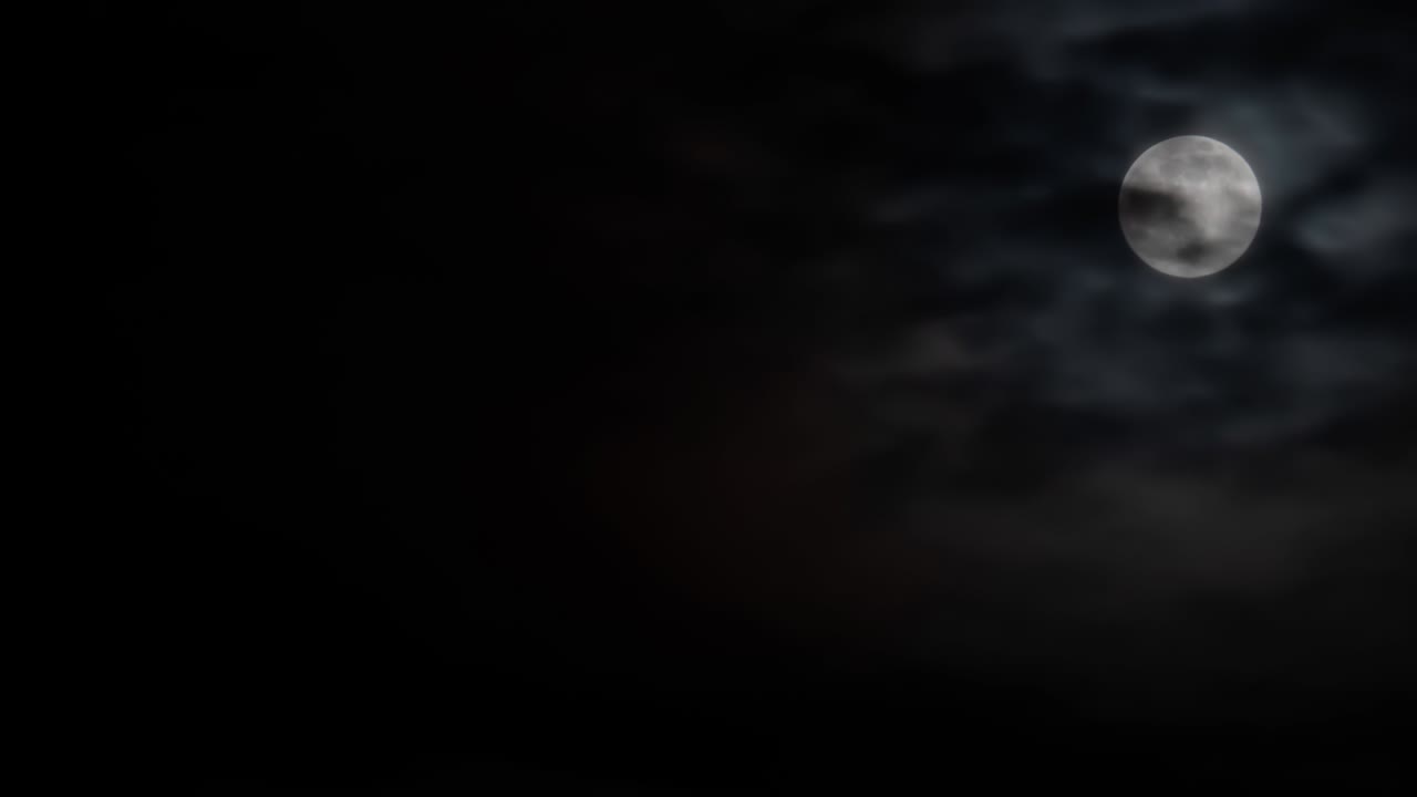 Timelapse - luna piena che sorge contro il cielo nero con nuvole in movimento di notte