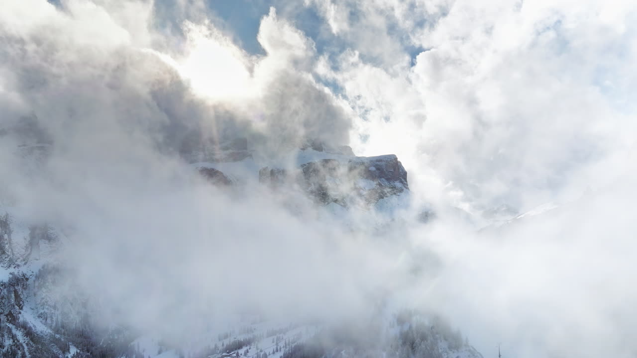Aerial drone view of the Gardena Pass high mountain pass in the clouds, in the Dolomites, Italy