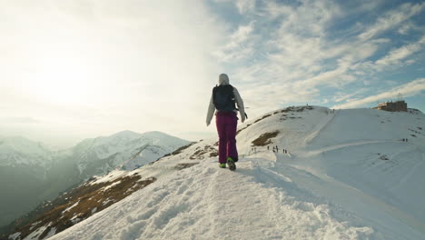walking on the snowy ridge of mountain to the peak in tatra mountains. - follow shot