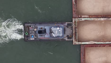 Tow-boat-pushing-hopper-barge-on-Ohio-river,-top-down-close-up-of-pusher-boat