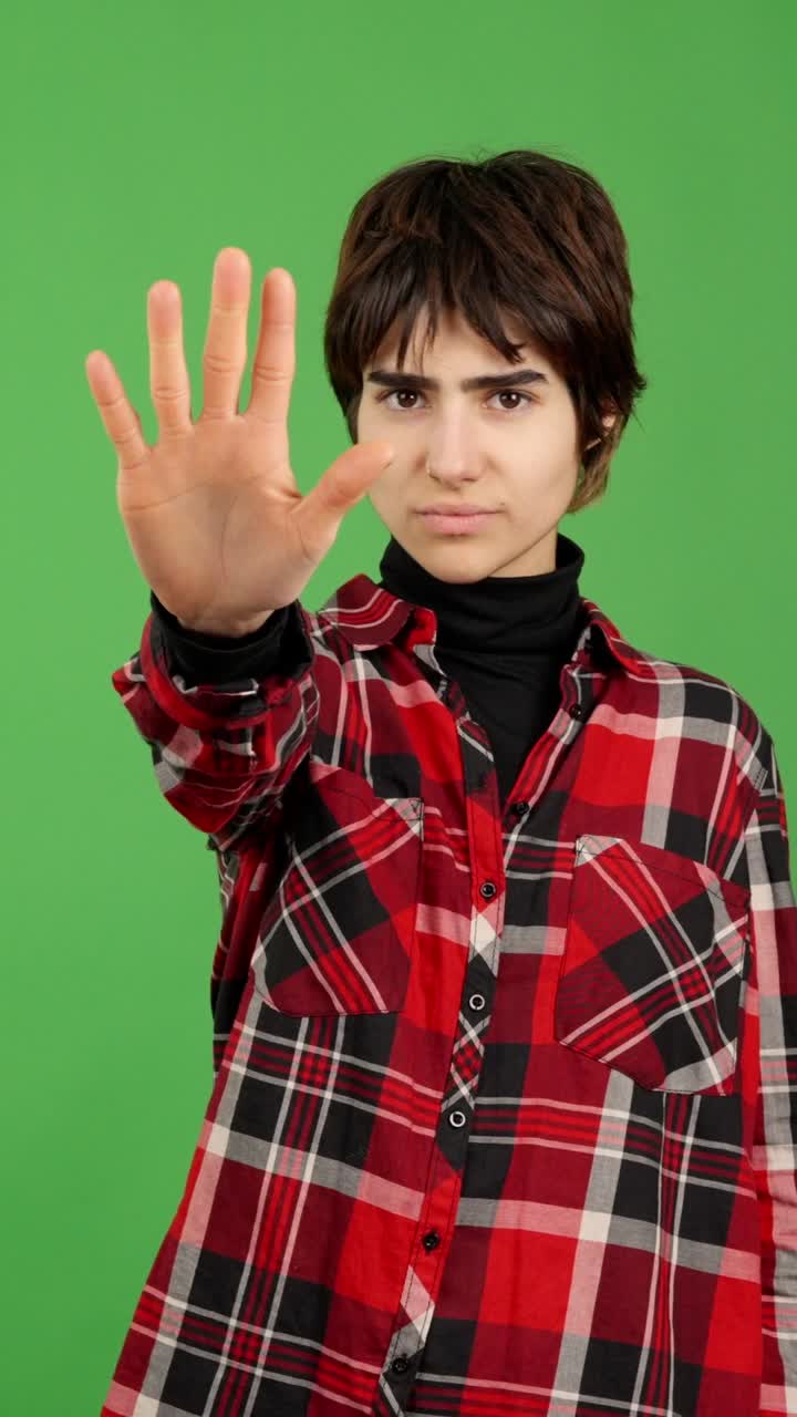 Young person showing a stop gesture with their hand