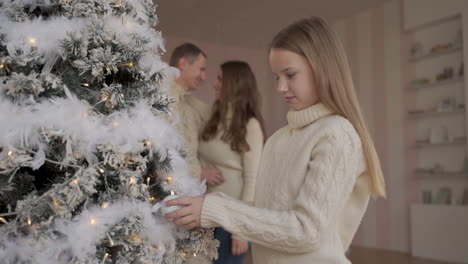 niña juega con pelotas y adornos de árbol de navidad