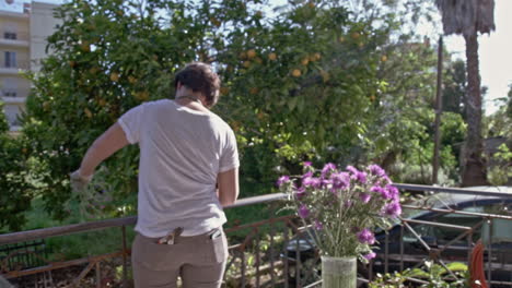 Woman-decorates-a-vaze-with-wildflowers-at-a-porch-of-a-countryhouse-60fps