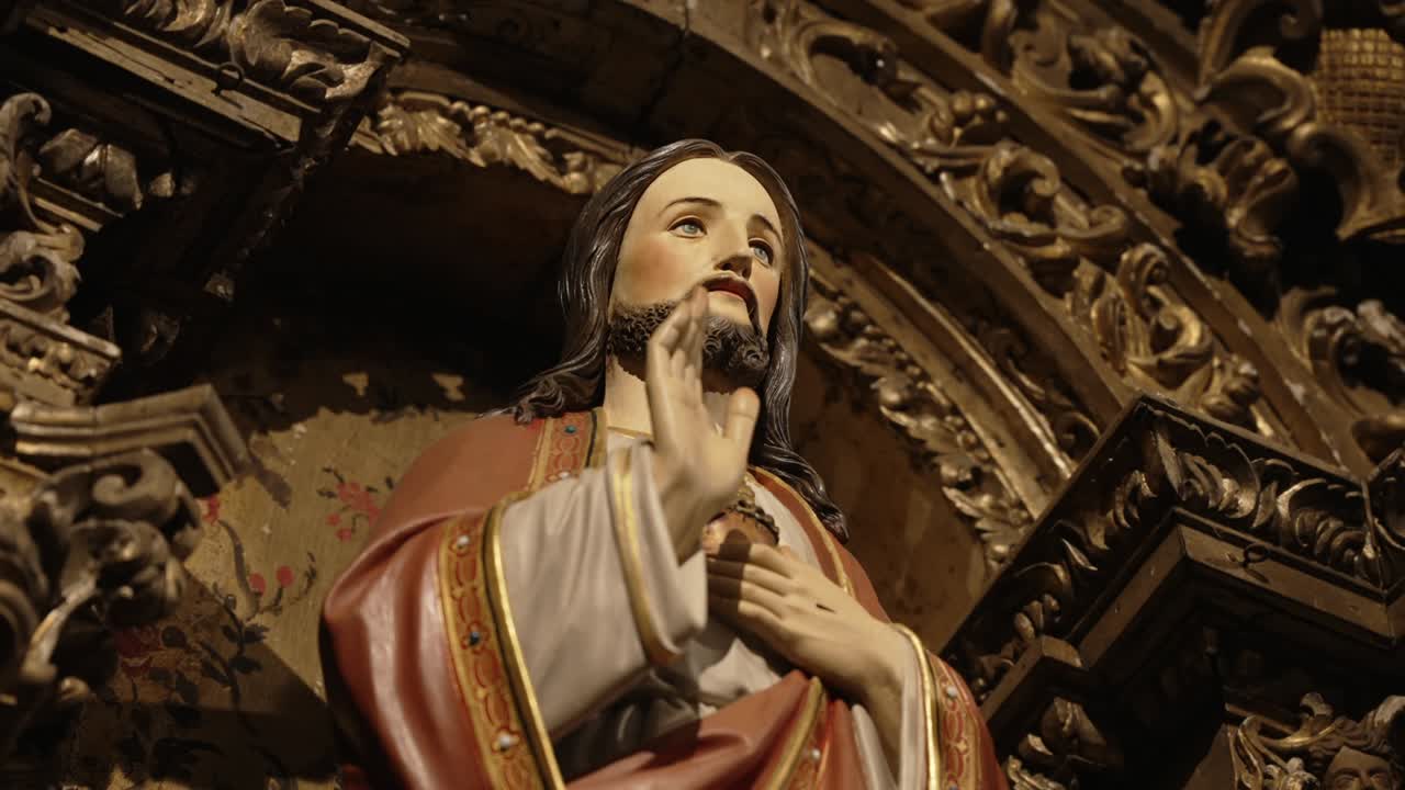 jesus christ’s hand raised in stillness beneath the weight of gilded devotion