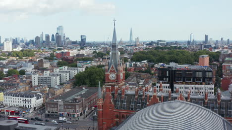 Slide-and-pan-footage-of-St-Pancras-train-station-clock-tower.-Traffic-in-streets-around.-London,-UK