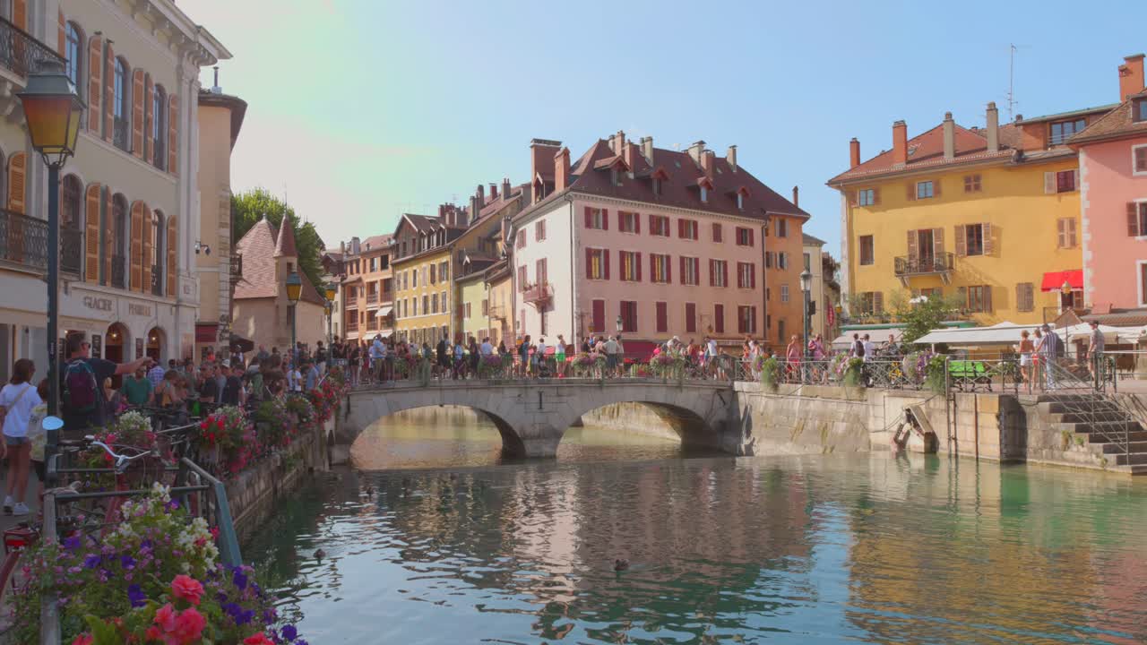 Tourists walking on an old bridge in a preserved medieval area of   Annecy, France