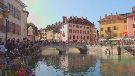 tourists walking on an old bridge in a preserved medieval area of   annecy, france
