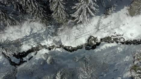 stream in wintry snowy mountain landscape in austria alps