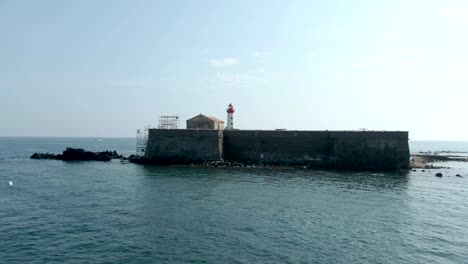 aproximación aérea de un fuerte marítimo con un faro