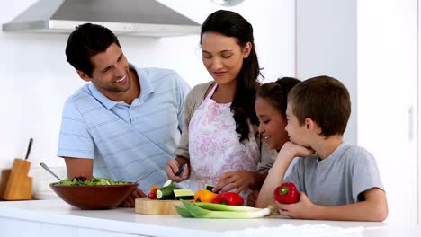 Madre-Mostrando-A-Los-Niños-Cómo-Cortar-Verduras.