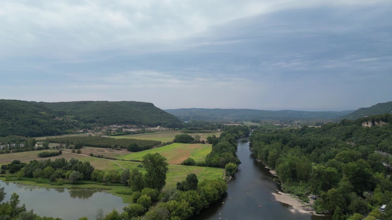 Veduta aerea con drone nella campagna francese che sorvola una verde foresta montana in una giornata di sole a Beynac et Cazenac.